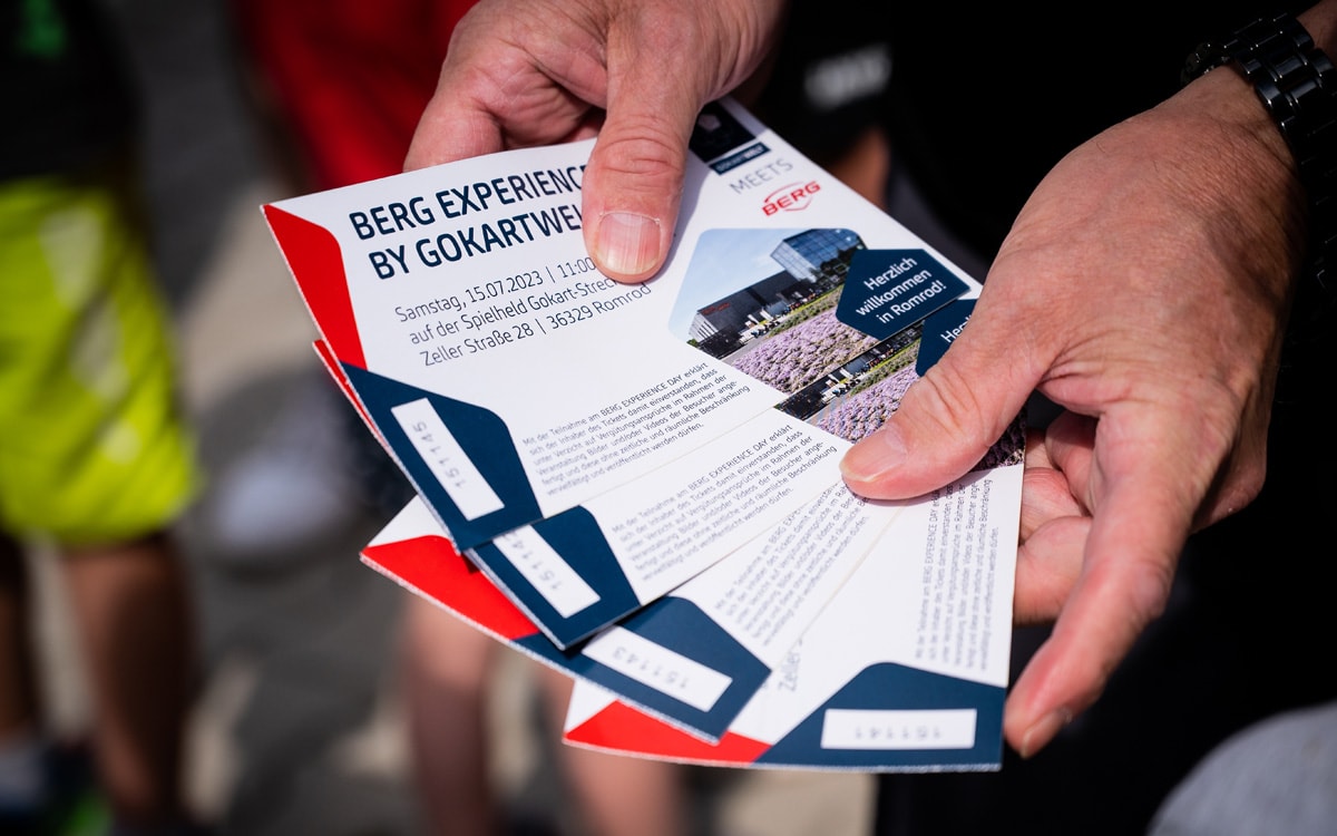 Zwei Hände halten vier Eintritts-Karten für den BERG Experience Day im Juli 2023.