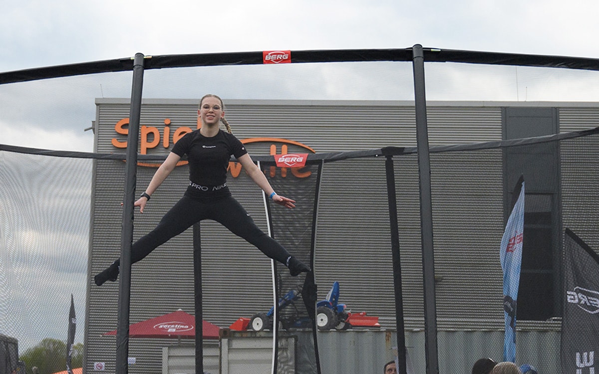 Ein Mädchen springt auf dem Trampolin und macht Akrobatik.