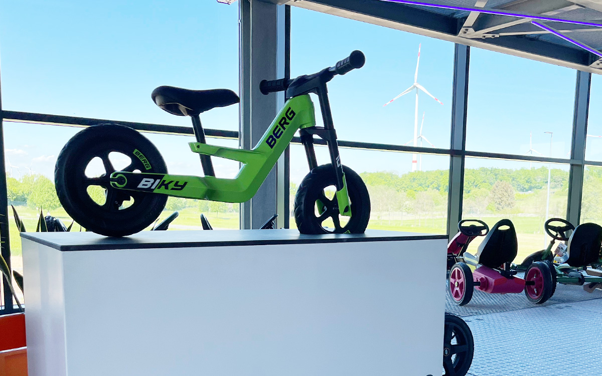 Vor Gokarts steht ein BERG Biky Laufrad zum Anfassen im Verkaufsraum bzw. Ausstellungsraum des Spielheld-Towers.