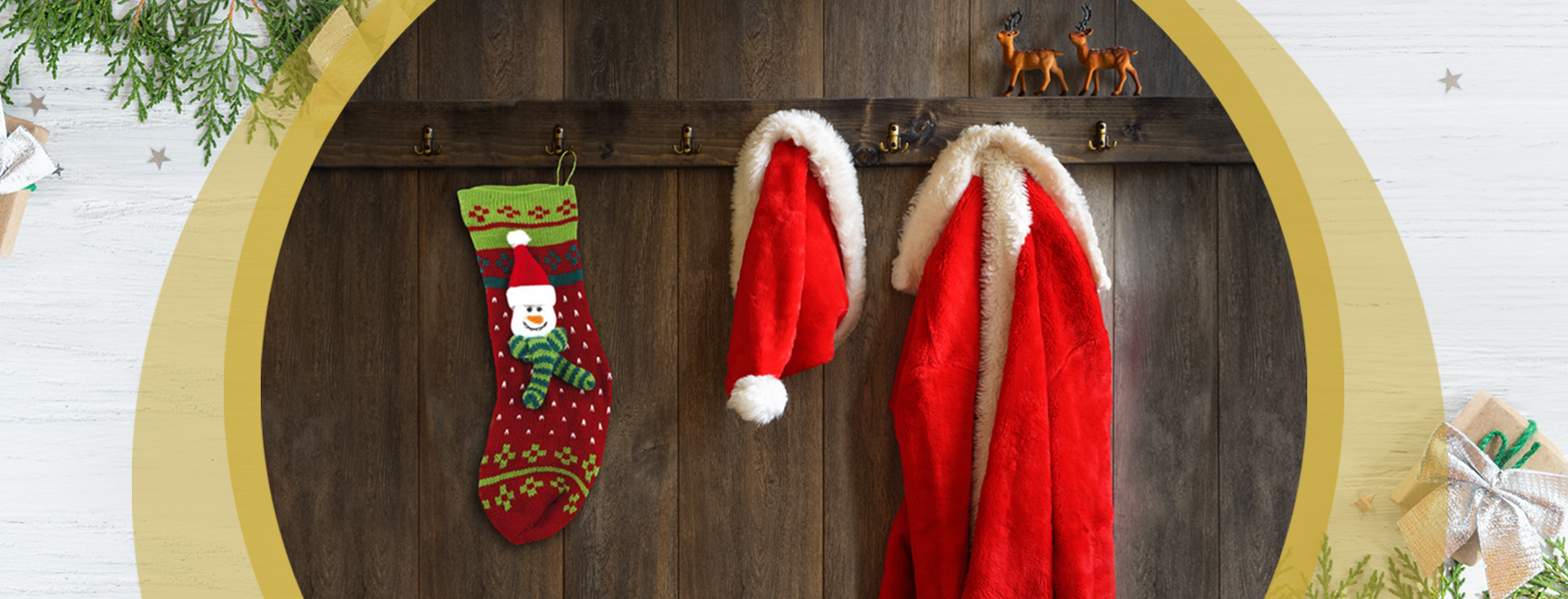 Eine Nikolaus-Socke hänge neben einer Nikolausmütze und dem passenden Mantel an einer Garderobe an der Wand